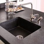 Op maat gemaakte keuken met onderkasten gemaakt van eikenhout met daarin paneeldeuren. In combinatie met een aanrechtblad, spoelbak van Belgisch hardsteen.
