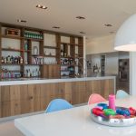 Massief rustieke eiken keuken, op maat gemaakt. De achterwand van de keuken heeft een kast met open vakken. Het RVS kookeiland is voorzien van eiken laden.