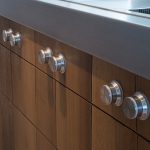Massief rustieke eiken keuken, op maat gemaakt. De achterwand van de keuken heeft een kast met open vakken. Het RVS kookeiland is voorzien van eiken laden.