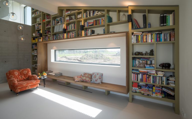 Boekenkast op maat gemaakt, meelopend in het lijnenspel van de buitengevel van de woning. De boekenkast is gemaakt van MDF in een warm groene kleur gespoten.