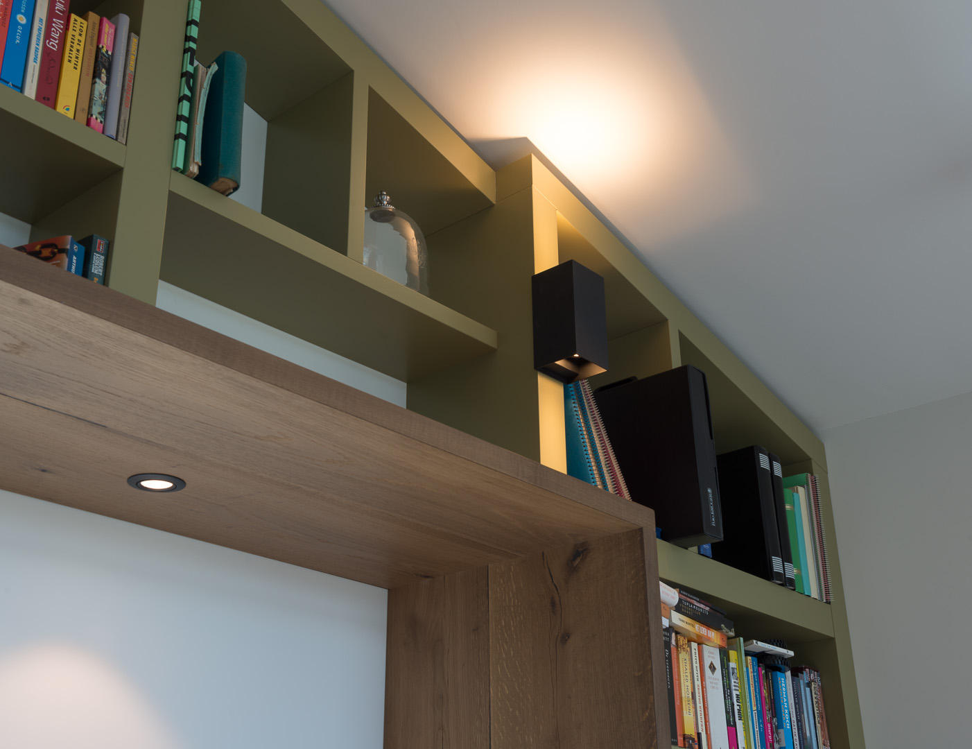 Boekenkast op maat gemaakt, meelopend in het lijnenspel van de buitengevel van de woning. De boekenkast is gemaakt van MDF in een warm groene kleur gespoten.