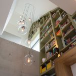 Boekenkast op maat gemaakt, meelopend in het lijnenspel van de buitengevel van de woning. De boekenkast is gemaakt van MDF in een warm groene kleur gespoten.