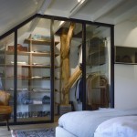 Garderobekast op maat gemaakt. Combinatie van eikenhouten planken, een origineel gebint en een glazen afscheidingswand met de slaapkamer.