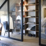 Garderobekast op maat gemaakt. Combinatie van eikenhouten planken, een origineel gebint en een glazen afscheidingswand met de slaapkamer.